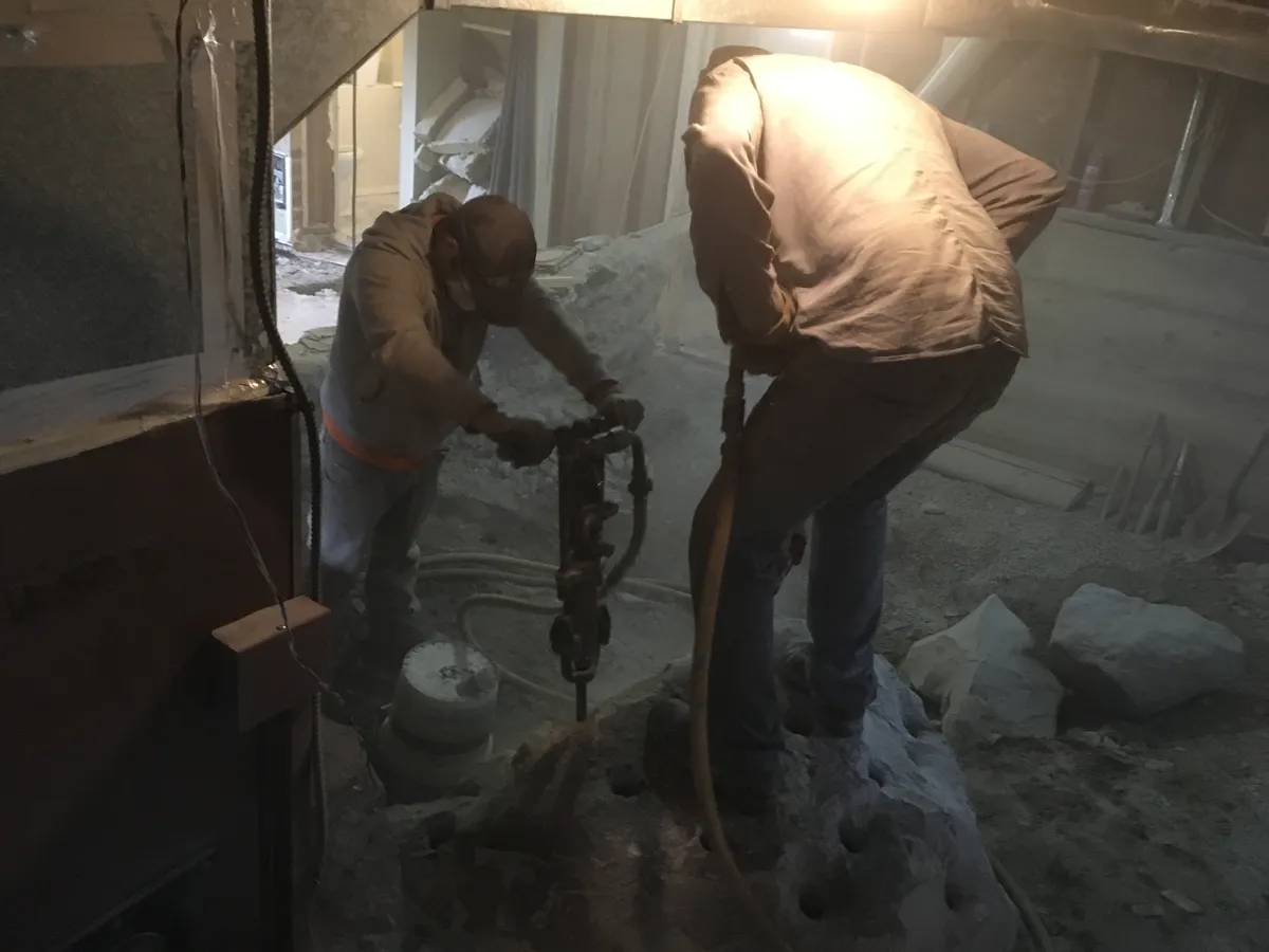 Drilling and breaking rock in basement excavation