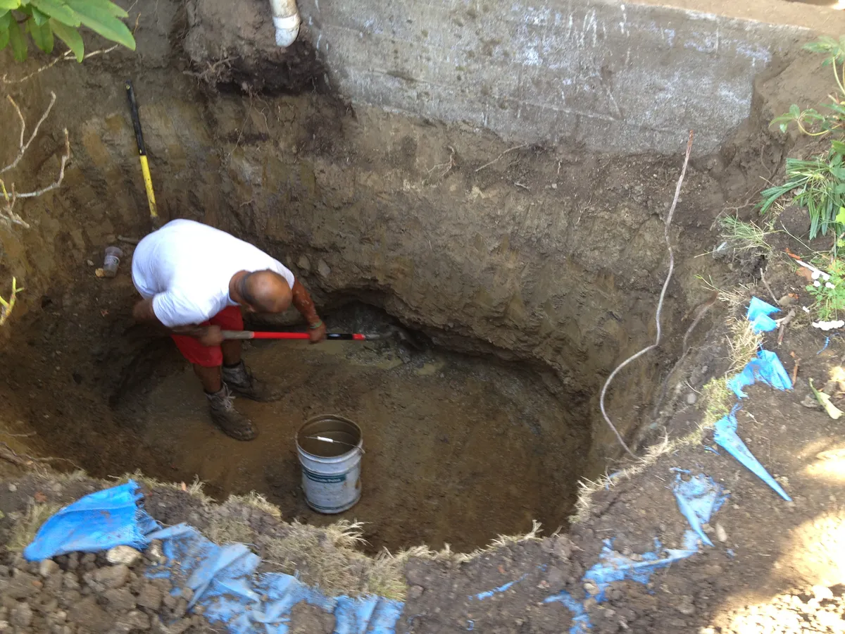 Hand excavating oil contaminated soil