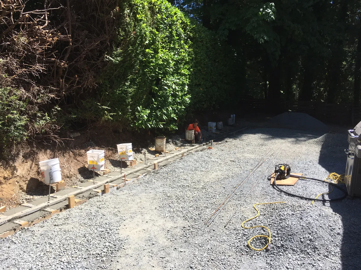 Concrete footings for retaining wall construction